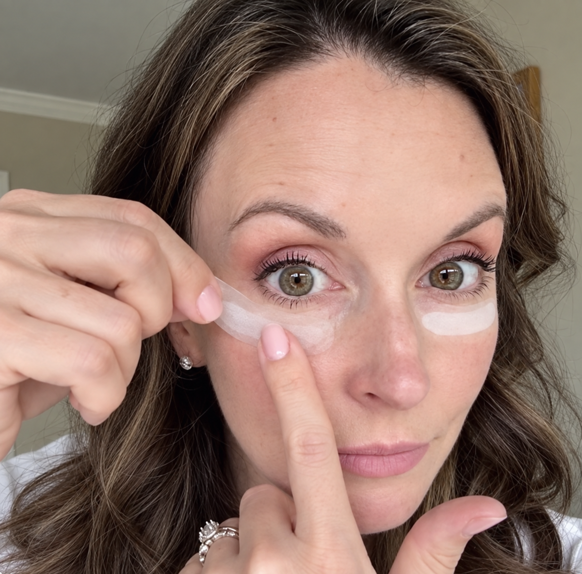 Mujer aplicándose parches de microagujas bajo los ojos